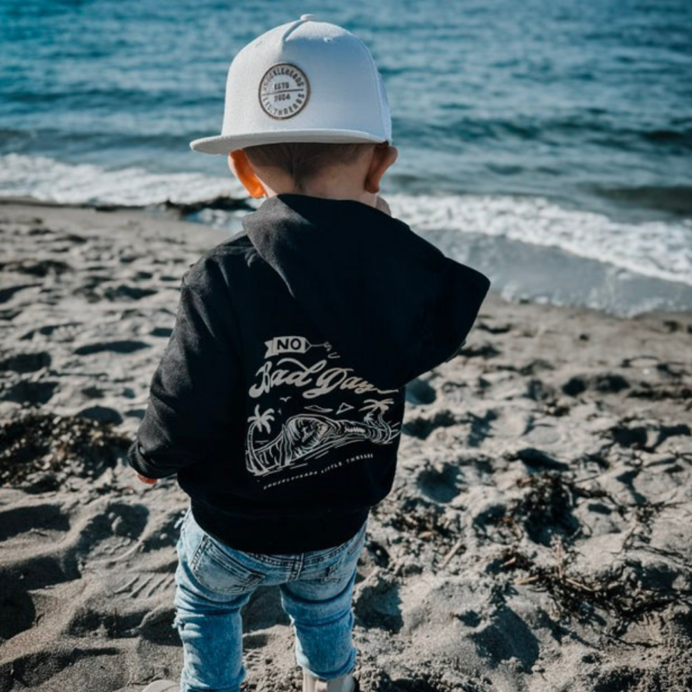 Hawaii Off White Snapback hat for infants and toddlers, crafted from 100% cotton for soft, comfortable wear. Features a medium-profile, structured 5-panel crown with a flat bill and adjustable snapback closure for a perfect fit as they grow. Embroidered tan Knuckleheads patch adds a stylish touch, ideal for little adventurers