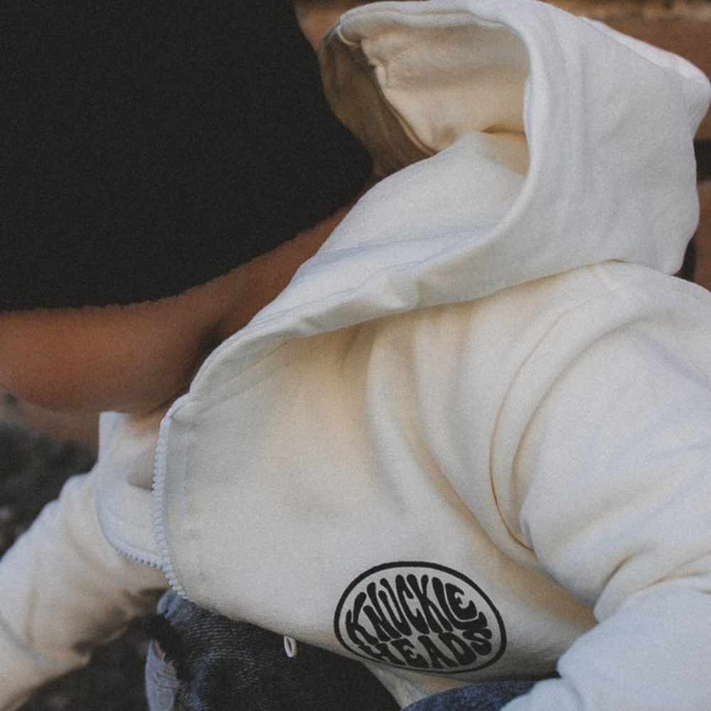 Pismo Off-White Baby Hoodie for infants, featuring a soft, cozy fabric and adjustable hood. Designed with a surf-inspired look in a fresh off-white color, and an easy zip-up front for quick changes. Perfect for active kids on beach days or casual outings, combining comfort with stylish, laid-back vibes.