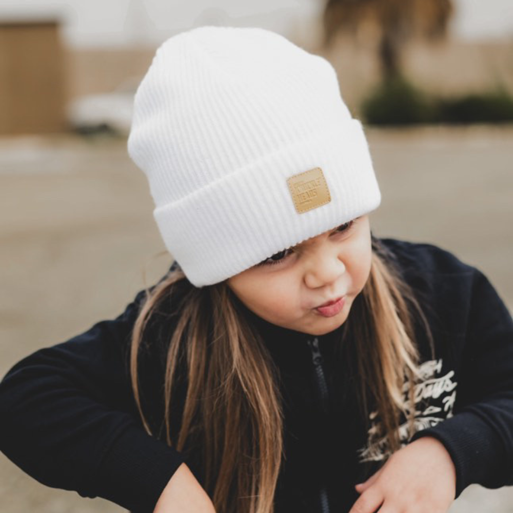 child wearing white baby beanie