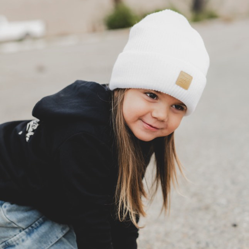 child wearing white baby beanie