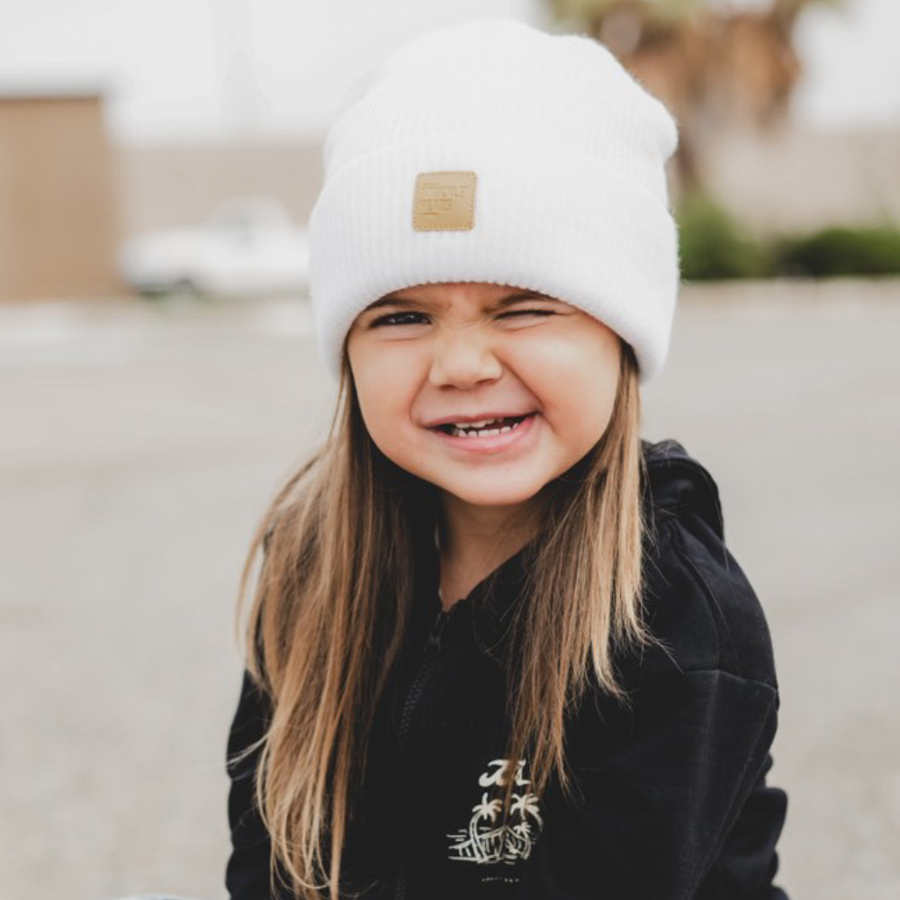 child wearing white baby beanie