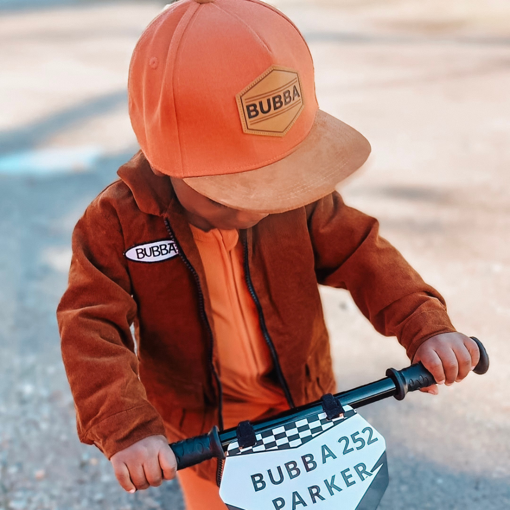 Image of Orange Kids Trucker Hat with 'Bubba' Patch: A vibrant and stylish accessory designed for kids. In a lively orange hue, it features a playful 'Bubba' patch on the front. Elevate your child's style with this fashionable hat, perfect for adding a pop of color to their outfits. Crafted with care, this orange kids trucker hat with the 'Bubba' patch is a must-have addition to their wardrobe, suitable for various occasions and everyday wear.