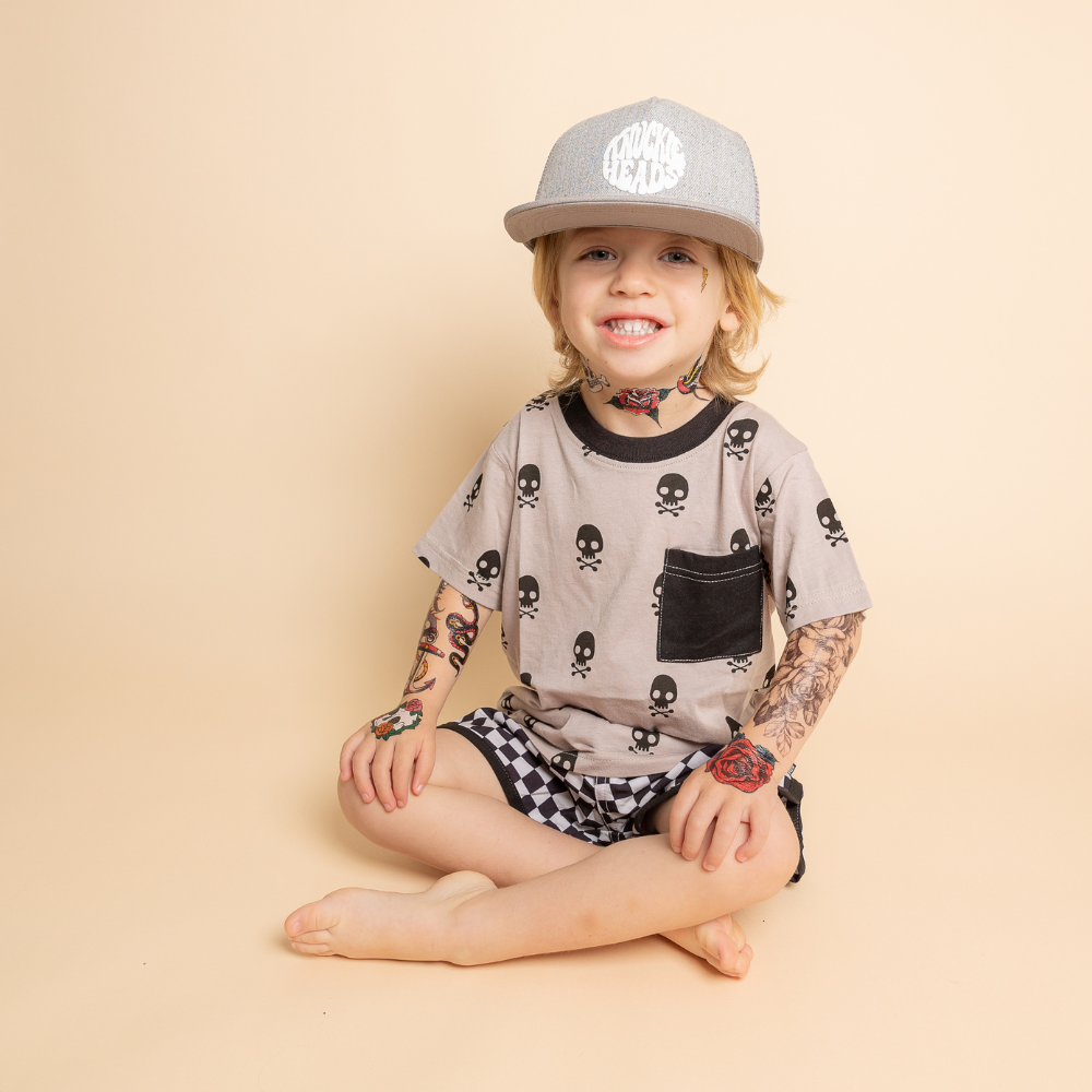 Image of Grey Bill Kids Trucker Hat with Knuckleheads Patch: A cool and trendy trucker hat designed for kids. The hat features a stylish tan crown and a brown bill, adorned with a striking Knuckleheads patch on the front. Elevate your child's style with this fashionable and comfortable accessory, perfect for any adventure or everyday wear. Crafted with care, this grey with grey bill trucker hat with a Knuckleheads patch is a must-have addition to their wardrobe.