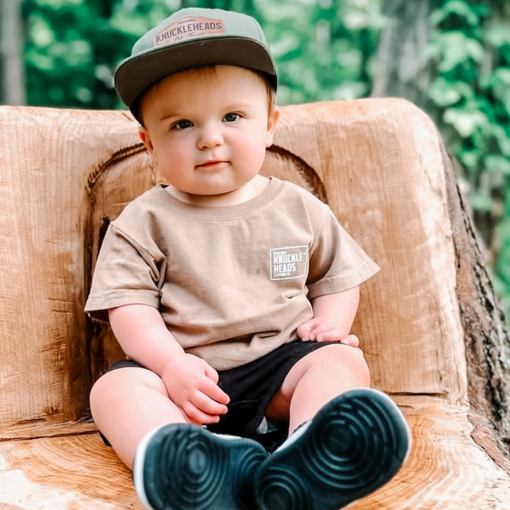 Image of Green Kids Trucker Hat with Knuckleheads Patch: A vibrant and stylish accessory designed for kids. In a lively green hue, it showcases a striking Knuckleheads patch on the front. Elevate your child's style with this fashionable hat, perfect for adding a pop of color to their outfits. Crafted with care, this green kids trucker hat with the Knuckleheads patch is a must-have addition to their wardrobe, suitable for various occasions and everyday wear.