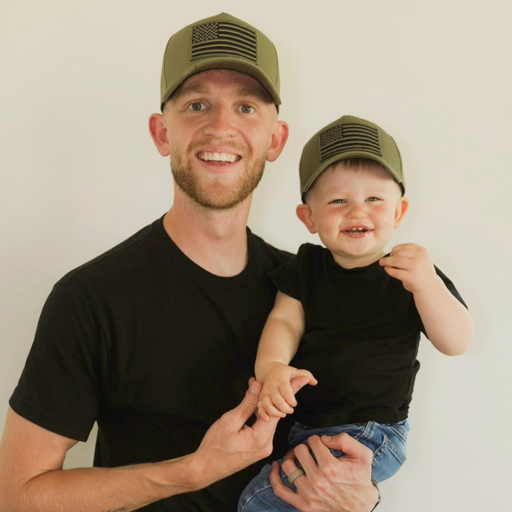 Image of Khaki Kids Trucker Hat with USA Flag Patch: A patriotic and stylish accessory designed for kids. In a versatile khaki shade, it features a prominent USA flag patch on the front. Elevate your child's style with this fashionable hat, perfect for adding a touch of national pride to their outfits.