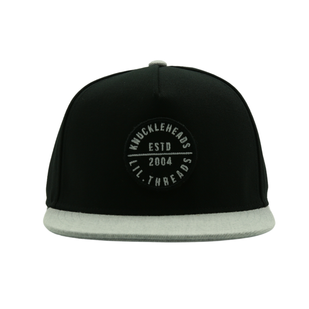 Presenting a Kids Trucker Hat in stylish Black and Grey, featuring an iconic Knuckleheads patch. This hat is specially designed for children, combining the versatile black and grey tones with the classic Knuckleheads patch. A standout accessory in our collection, it adds a touch of coolness and personality to your little one's look.