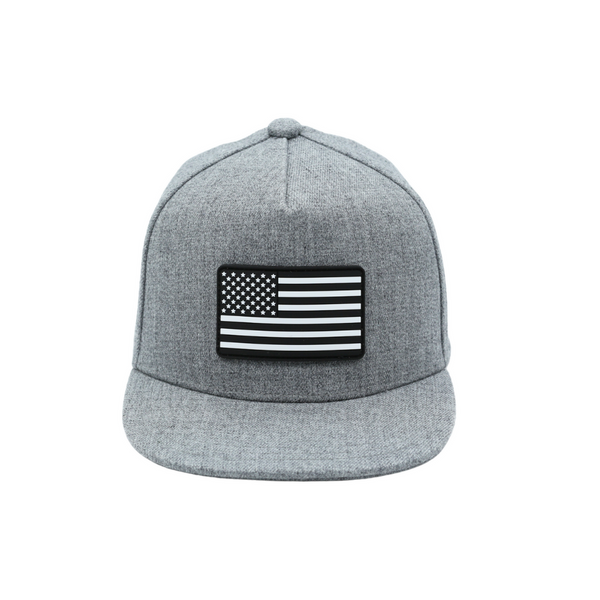 Image of Grey USA Kids Trucker Hat with Black and White USA Flag Patch: A stylish and patriotic trucker hat designed for kids. The hat comes in a trendy grey color, featuring a striking black and white USA flag patch on the front. Elevate your child's style while proudly displaying their American spirit. Perfect for outdoor adventures and everyday wear, this hat is a fashionable and functional addition to their wardrobe.