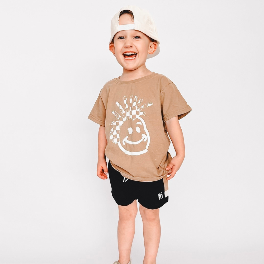 Image of Tan Kids T-Shirt with Knuckleheads Logo: A stylish and versatile addition to kids' wardrobes. This tan-colored t-shirt features the iconic Knuckleheads logo on the front. Keep your child's style on point with this comfortable shirt, perfect for adding a touch of character to their outfits.