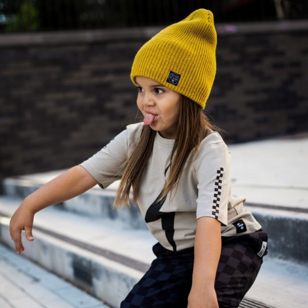 Image highlighting a vibrant yellow beanie from Knuckleheads, designed for children. This versatile beanie, complete with the Knuckleheads brand tag, offers a classic style suitable for infants and toddlers. A cheerful addition to the collection of Infant hats, adding a bright touch of charm.