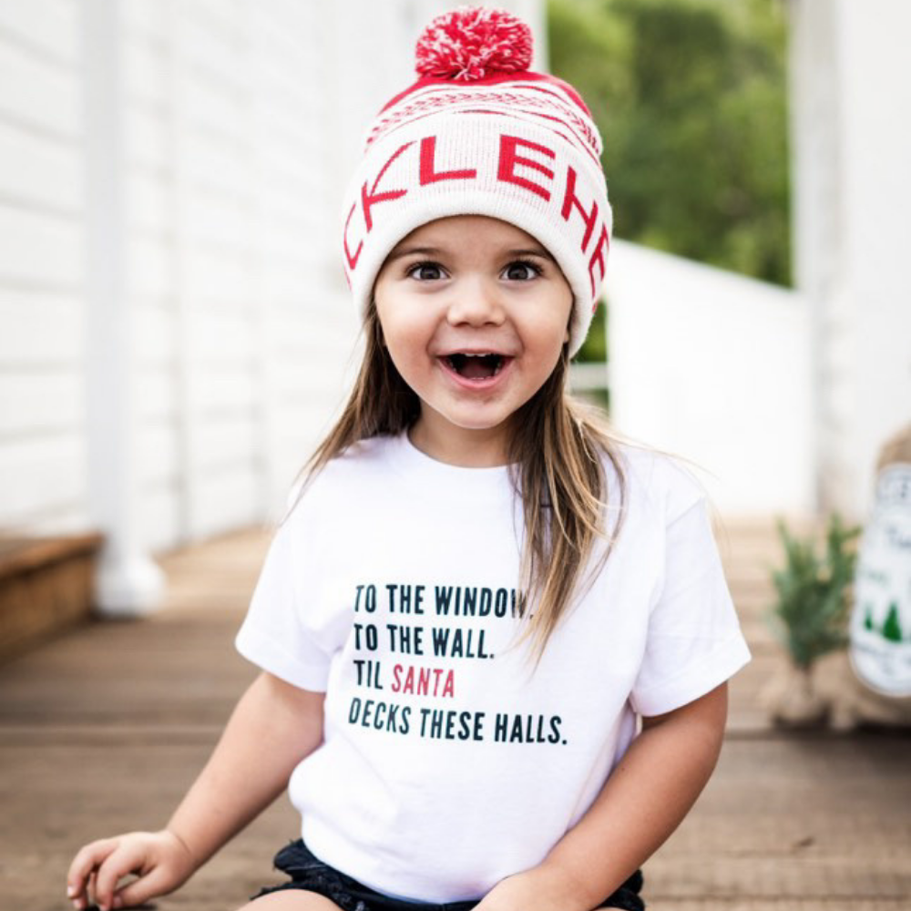 Image displaying a red and white fold-up beanie with a pom from Knuckleheads, designed for children. This versatile beanie combines a classic style with the Knuckleheads brand tag, perfect for infants and toddlers. A playful addition to the collection of Infant hats, enhancing its charm.