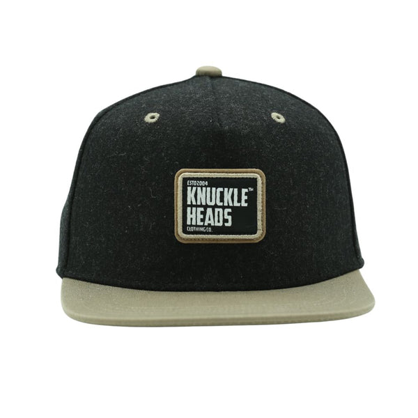 Stylish Tahoe Snapback for infants, toddlers, and youth, featuring a 5-panel structured crown and flat bill. Adjustable snapback closure for a custom fit. Made with a durable blend of wool, rayon, and polyester, this hat includes a unique Knuckleheads patch. Perfect for everyday wear and adventures