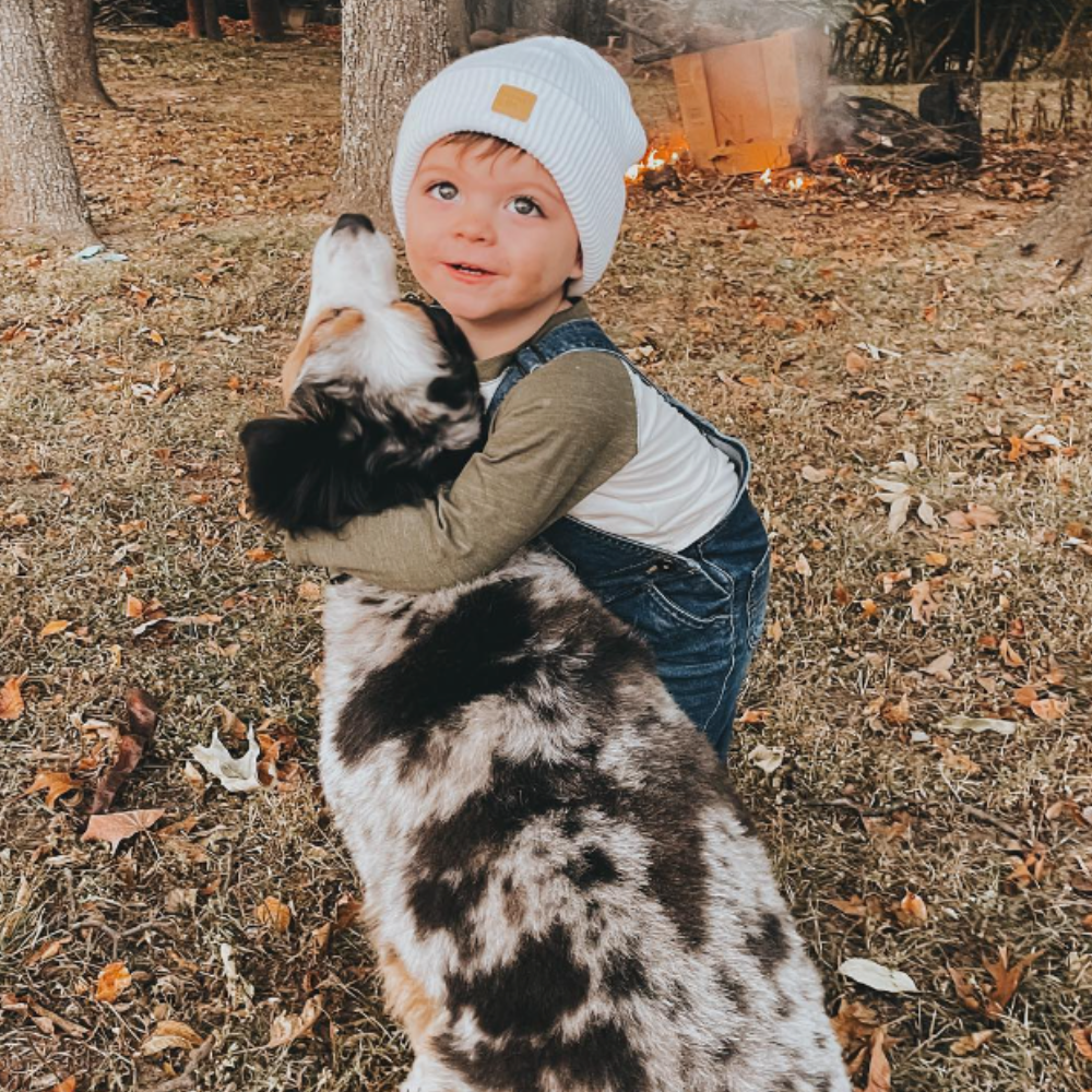 infant wearing white baby beanie