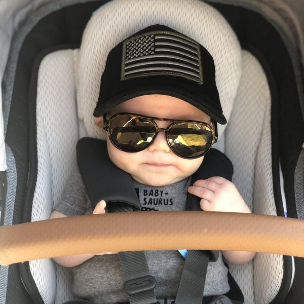 Image of Black Kids Trucker Hat with USA Flag Patch: A patriotic and stylish accessory designed for kids. In classic black, it features a prominent USA flag patch on the front. Elevate your child's style with this fashionable hat, perfect for adding a touch of national pride to their outfits.