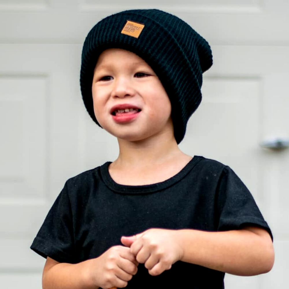 child wearing black beanie with patch